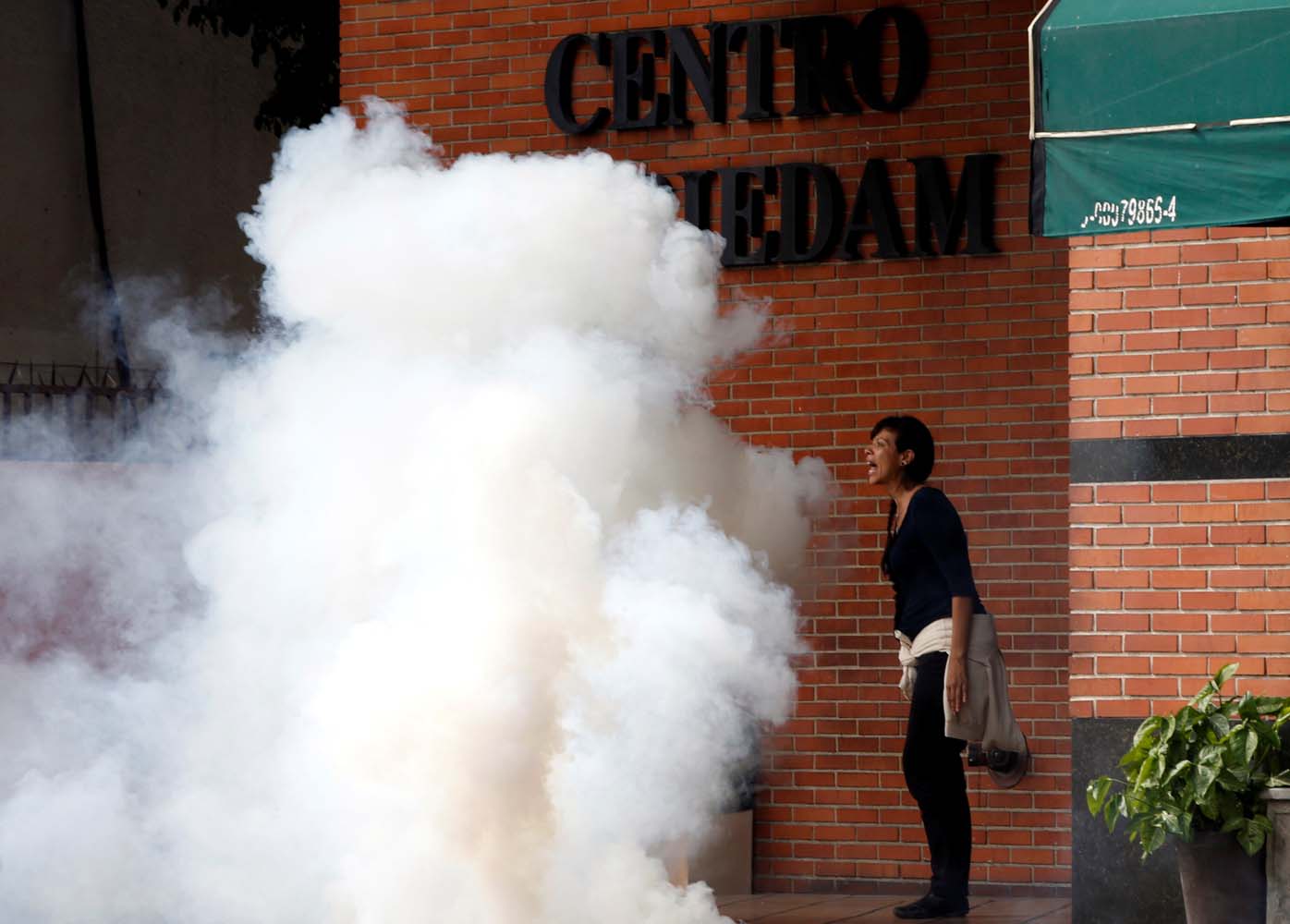 A woman reacts outside a restaurant after tear gas was fired by security forces during clashes at a rally against Venezuelan President Nicolas Maduro's government in Caracas, Venezuela, July 6, 2017. REUTERS/Andres Martinez Casares
