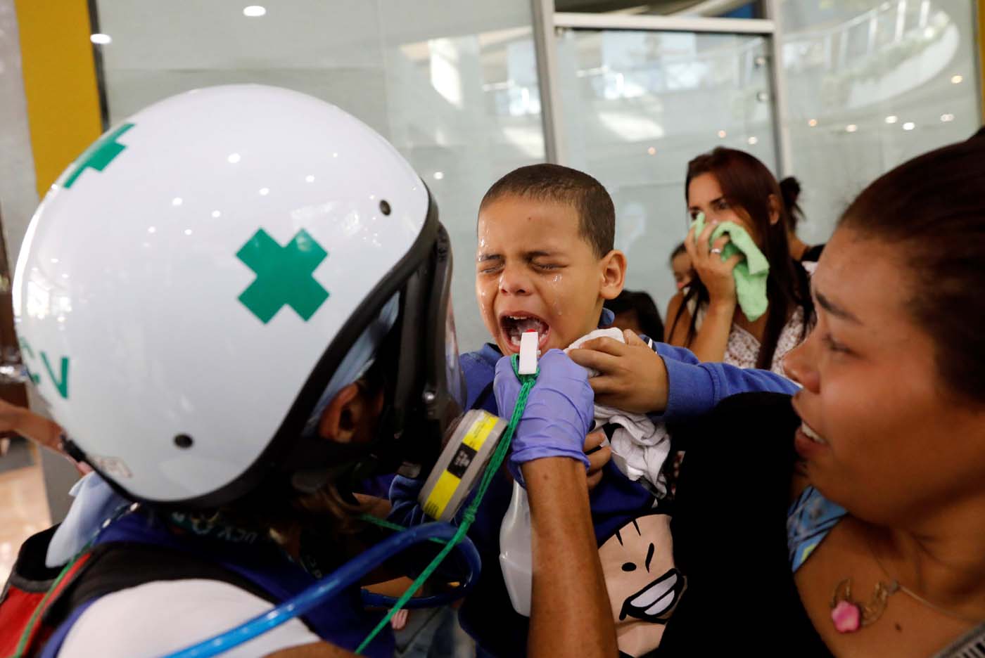 A child receives medical attention outside a shopping mall after being affected by smoke from tear gas fired by security forces during clashes at a rally against Venezuelan President Nicolas Maduro's government in Caracas, Venezuela, July 6, 2017. REUTERS/Andres Martinez Casares