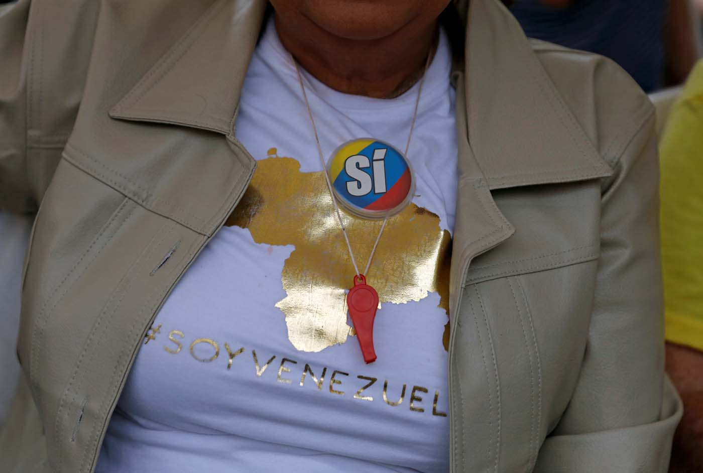 A woman wears a pin in the national colours reading "Yes" at a polling station during an unofficial plebiscite against Venezuela's President Nicolas Maduro's government and his plan to rewrite the constitution, in Caracas, Venezuela July 16, 2017. The writing on the T-shirt reads: "#I am Venezuela." REUTERS/Andres Martinez Casares