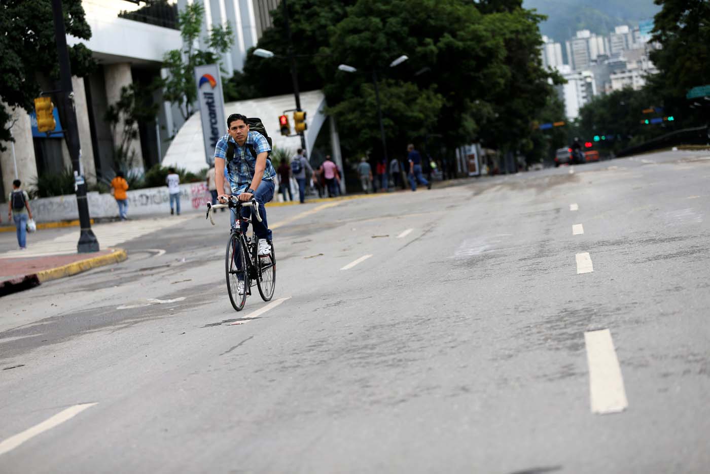 A man rides a bike along an empty road during a strike called to protest against Venezuelan President Nicolas Maduro's government in Caracas, Venezuela, July 20, 2017. REUTERS/Andres Martinez Casares