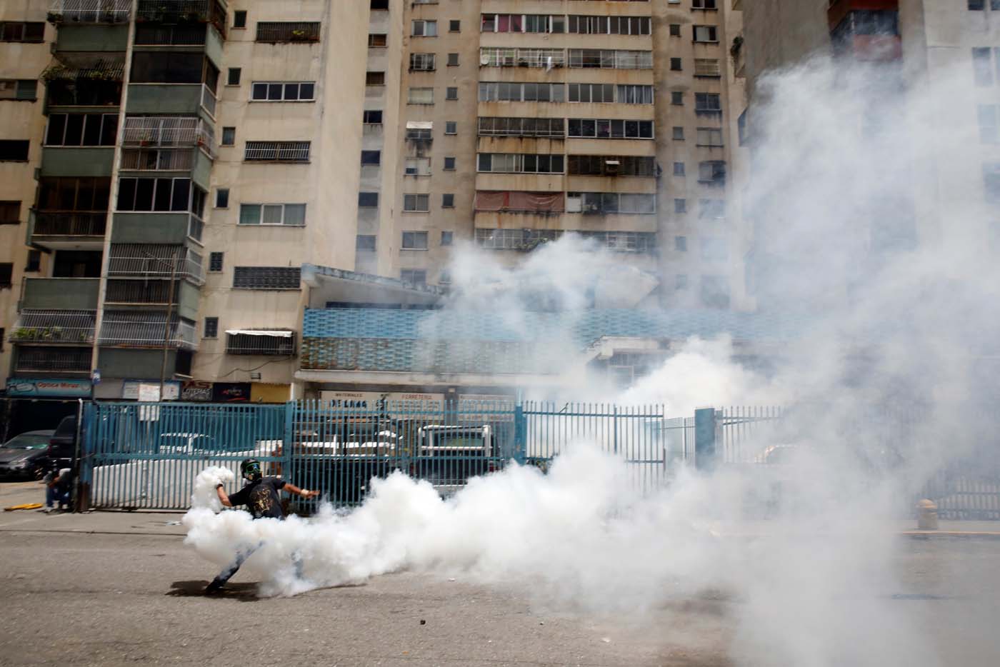 A demonstrator throws back a tear gas canister while clashing with riot security forces during a strike called to protest against Venezuelan President Nicolas Maduro's government in Caracas, Venezuela, July 20, 2017. REUTERS/Carlos Garcia Rawlins     TPX IMAGES OF THE DAY