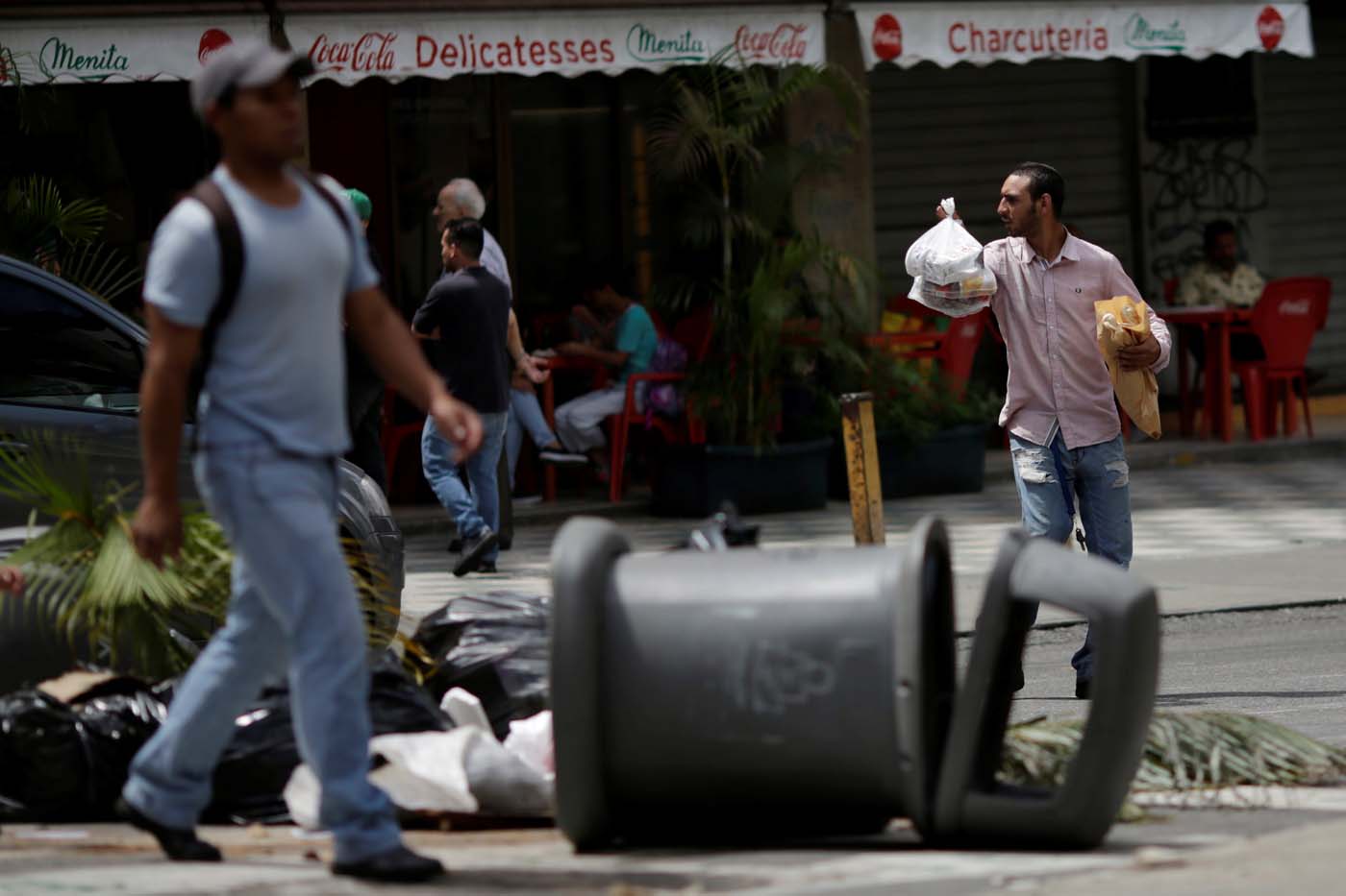 People walk through a barricade after a strike called to protest against Venezuelan President Nicolas Maduro's government in Caracas, Venezuela, July 29, 2017. REUTERS/Ueslei Marcelino