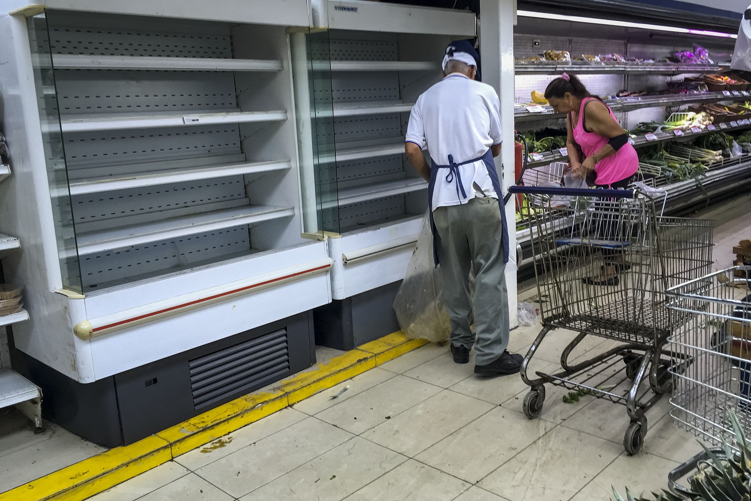 CAR24. CARACAS (VENEZUELA), 24/07/2017.- Personas buscan alimentos en un supermercado con estanterías parcialmente vacíos hoy, lunes 24 de julio de 2017, en Caracas (Venezuela). Numerosos supermercados de Caracas cerrarán hoy con más estanterías vacías de lo habitual después de que los habitantes de la capital hicieran acopio de alimentos y otros productos básicos ante el paro general contra el Gobierno que la oposición convocó para el miércoles y el jueves. EFE/MIGUEL GUTIÉRREZ
