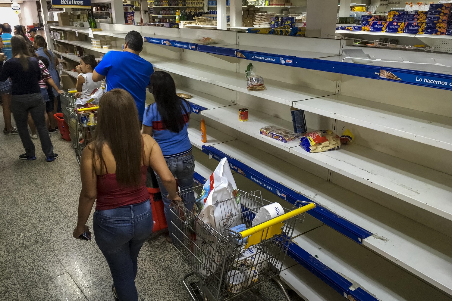 Personas buscan alimentos en un supermercado con estanterías parcialmente vacíos hoy, lunes 24 de julio de 2017, en Caracas (Venezuela). Numerosos supermercados de Caracas cerrarán hoy con más estanterías vacías de lo habitual después de que los habitantes de la capital hicieran acopio de alimentos y otros productos básicos ante el paro general contra el Gobierno que la oposición convocó para el miércoles y el jueves. EFE/MIGUEL GUTIÉRREZ