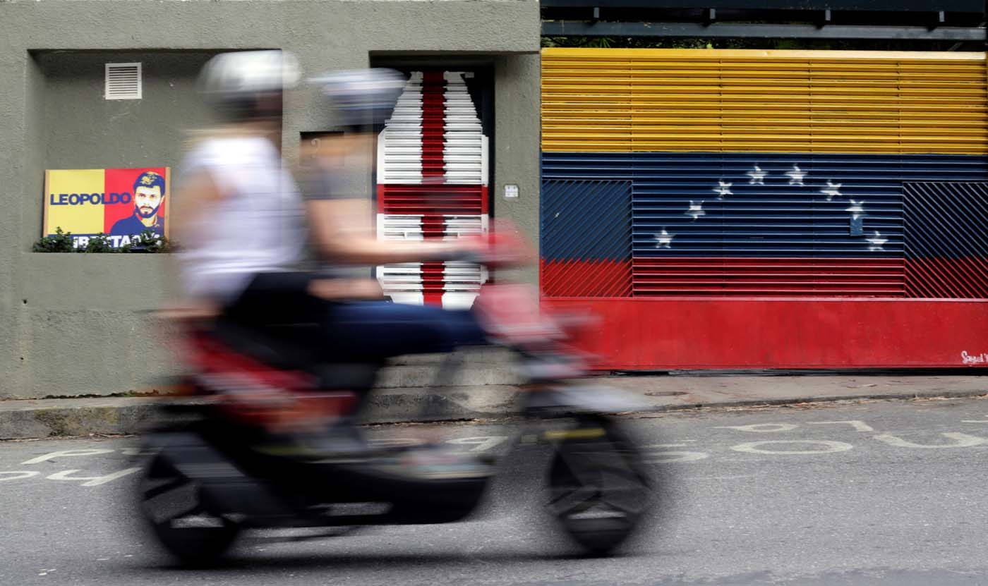 Two people ride a motorcycle past the house of Venezuelan opposition leader Leopoldo Lopez in Caracas, Venezuela August 1, 2017. REUTERS/Ueslei Marcelino