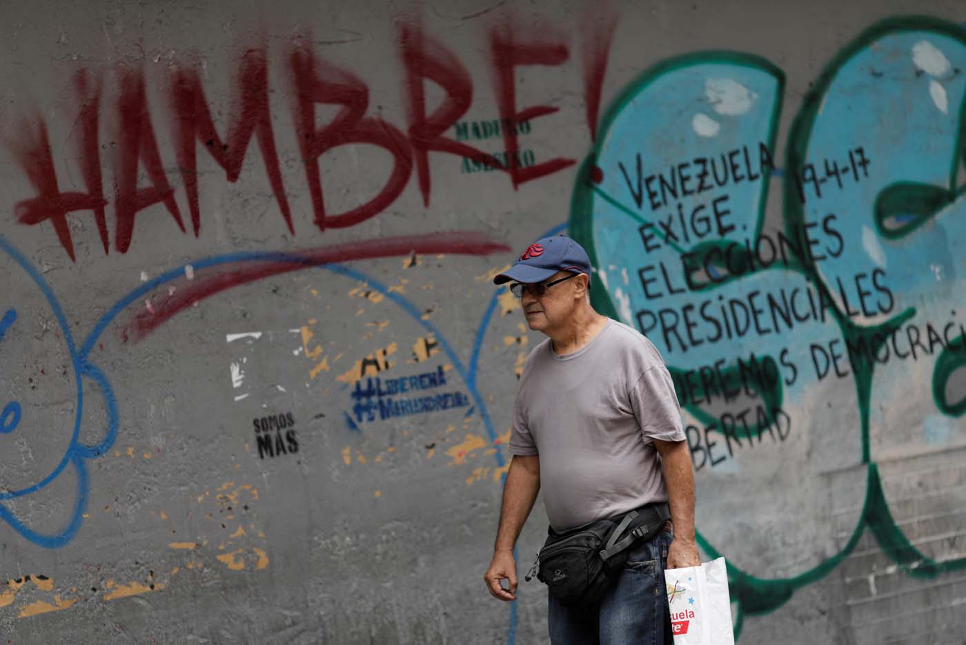 A man walks past of a wall with graffiti that reads "hungry", in Caracas, Venezuela August 3, 2017. REUTERS/Ueslei Marcelino