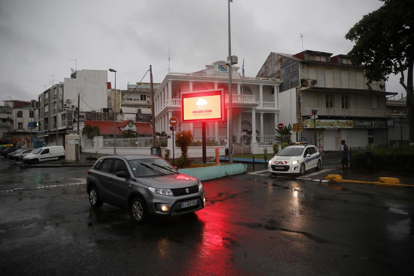 A car passes next to a banner warning of a "Red Alert" for rains as Hurricane Maria approaches in Pointe-a-Pitre, Guadeloupe island, France, September 18, 2017. REUTERS/Andres Martinez Casares