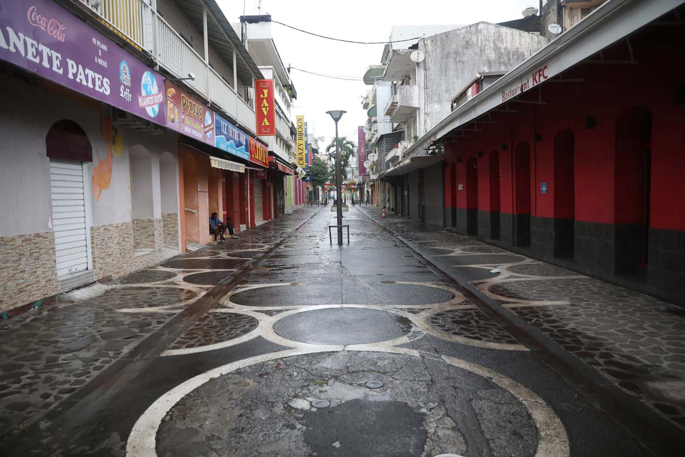 People sit on the side of an empty street as Hurricane Maria approaches in Pointe-a-Pitre, Guadeloupe island, France, September 18, 2017. REUTERS/Andres Martinez Casares