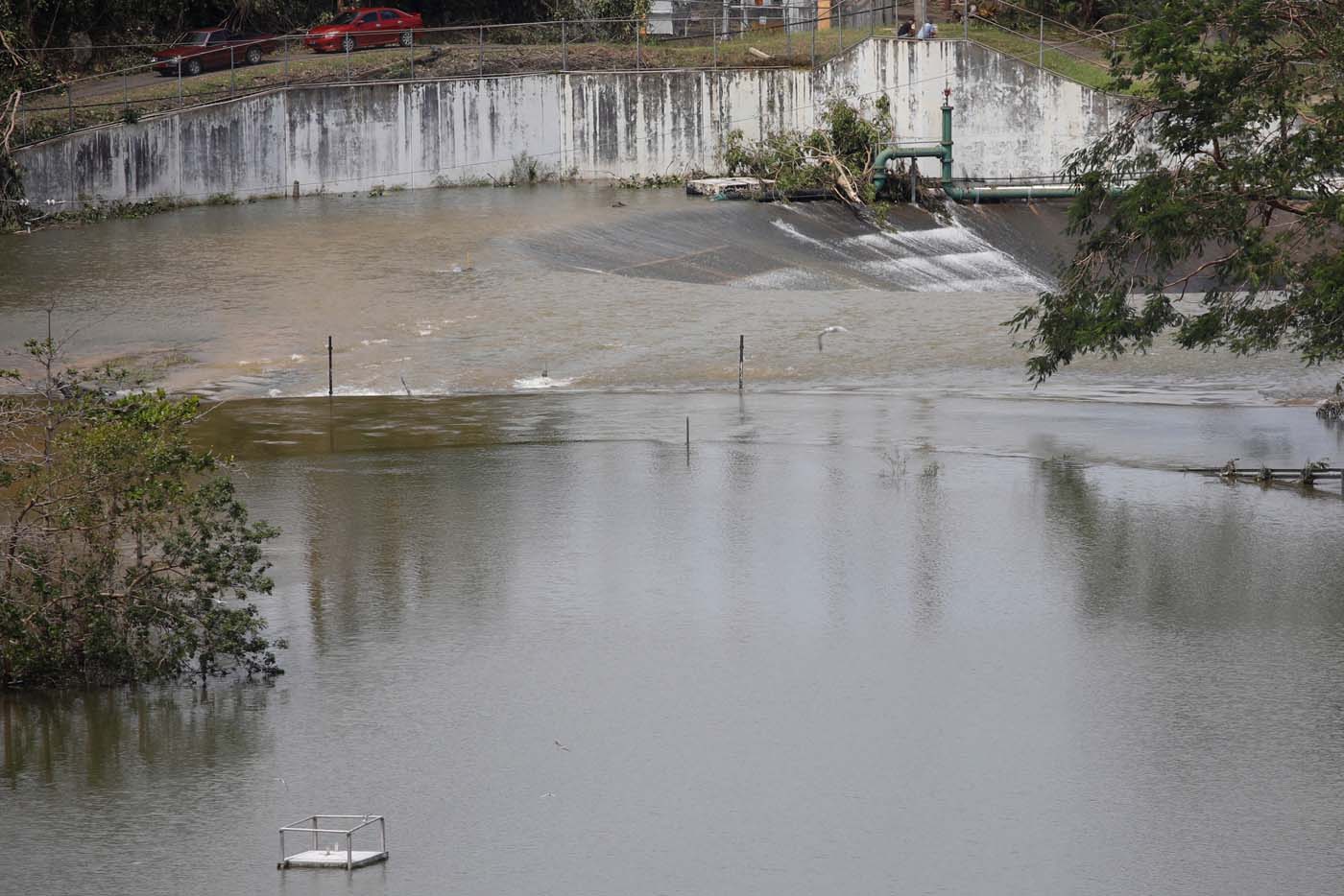 People look at water flowing over the road at the dam of the Guajataca lake after the area was hit by Hurricane Maria in Guajataca, Puerto Rico September 23, 2017. REUTERS/Carlos Garcia Rawlins