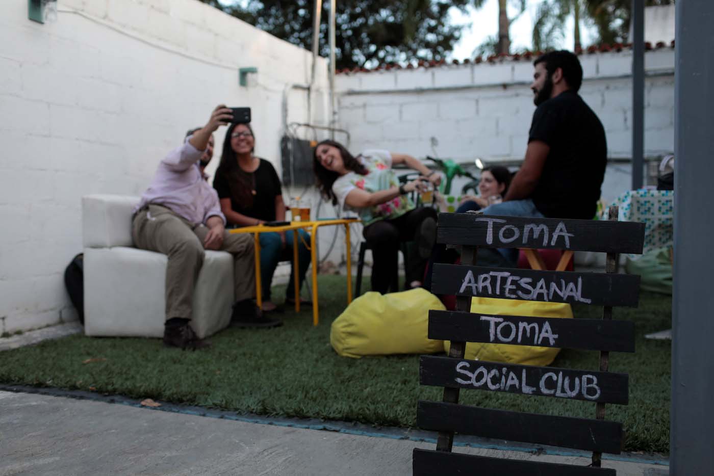 A sign that reads "Drink craft, drink Social Club" is displayed in a beer garden at the garage of a brewery in Caracas, Venezuela, September 15, 2017. Picture taken September 15, 2017. REUTERS/Marco Bello
