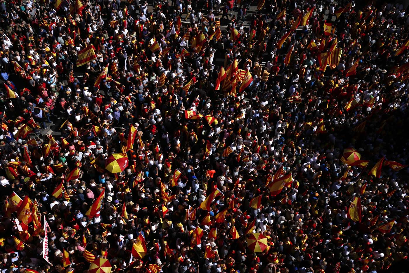 Protesters hold Spanish and Catalan flags during a demonstration called by "Societat Civil Catalana" (Catalan Civil Society) to support the unity of Spain on October 8, 2017 in Barcelona. Spain braced for more protests despite tentative signs that the sides may be seeking to defuse the crisis after Madrid offered a first apology to Catalans injured by police during their outlawed independence vote. / AFP PHOTO / PAU BARRENA
