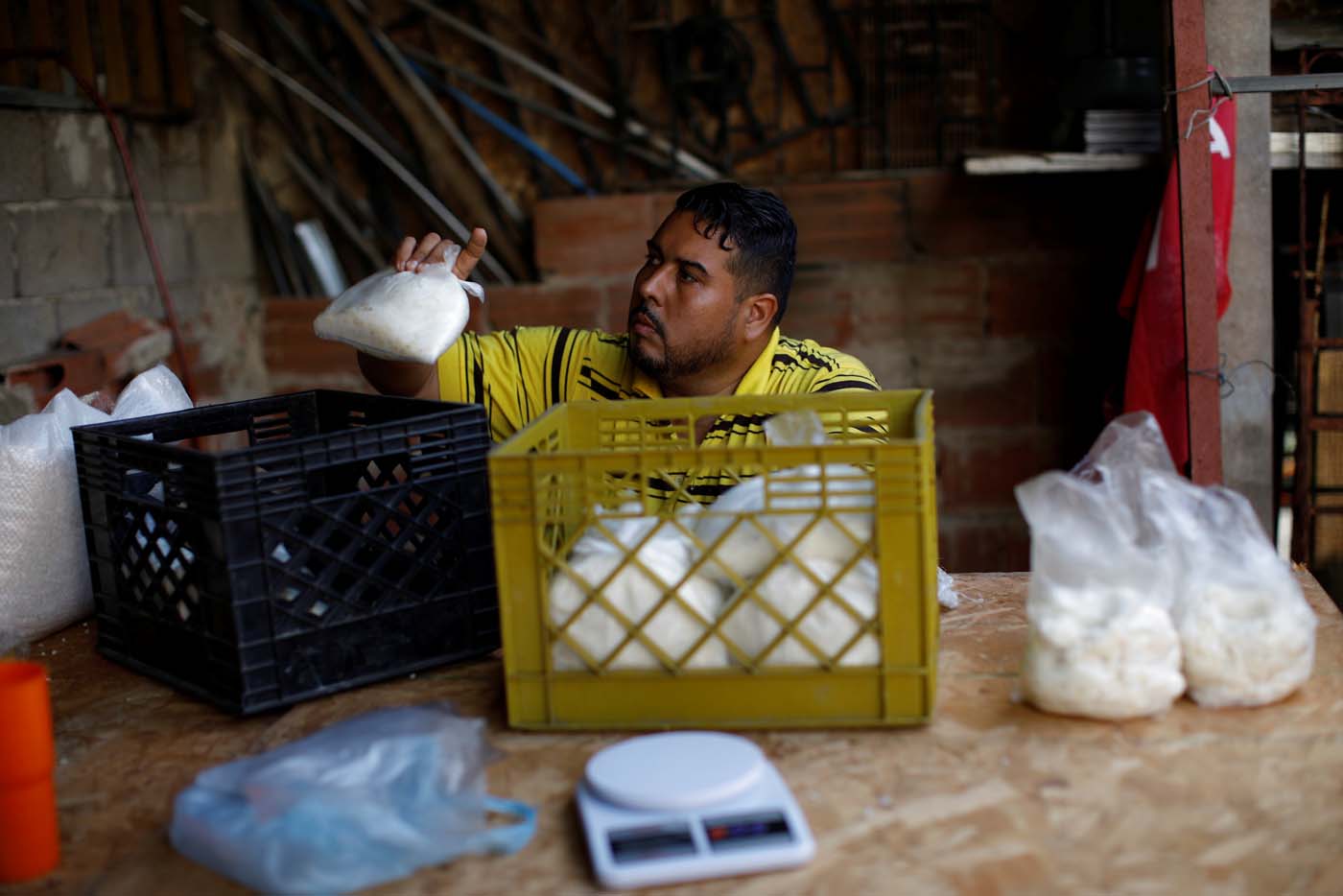 Medical equipment repairman Leandro Colmenares puts corn dough on plastic bags at the backyard of his house in Caracas, Venezuela October 3, 2017. Picture taken October 3, 2017. REUTERS/Carlos Garcia Rawlins