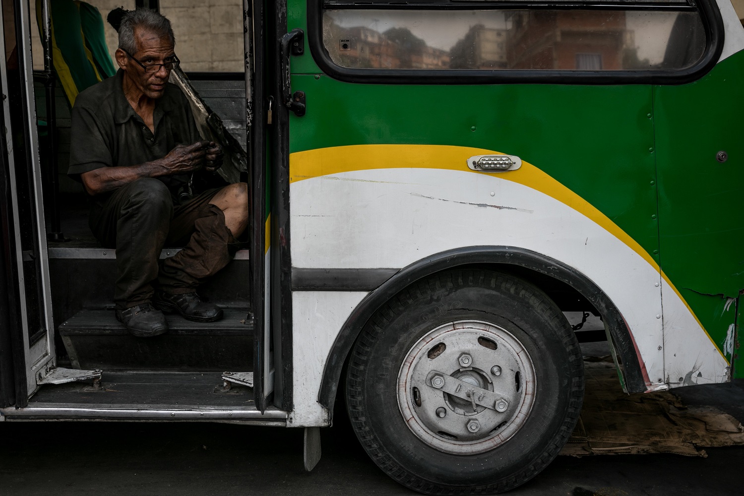 Fotografías del 10 de octubre del 2017, de un mecánico que trabaja en un bus de transporte público, en la ciudad de Caracas (Venezuela). Los altos costos de mantenimiento, la disminución de importación de repuestos, una galopante inflación y la escasez de efectivo tienen al sistema de transporte de Venezuela en jaque, mientras la población padece los efectos de esta crisis con un pasaje inestable y largos tiempos de espera para trasladarse. EFE/MIGUEL GUTIÉRREZ