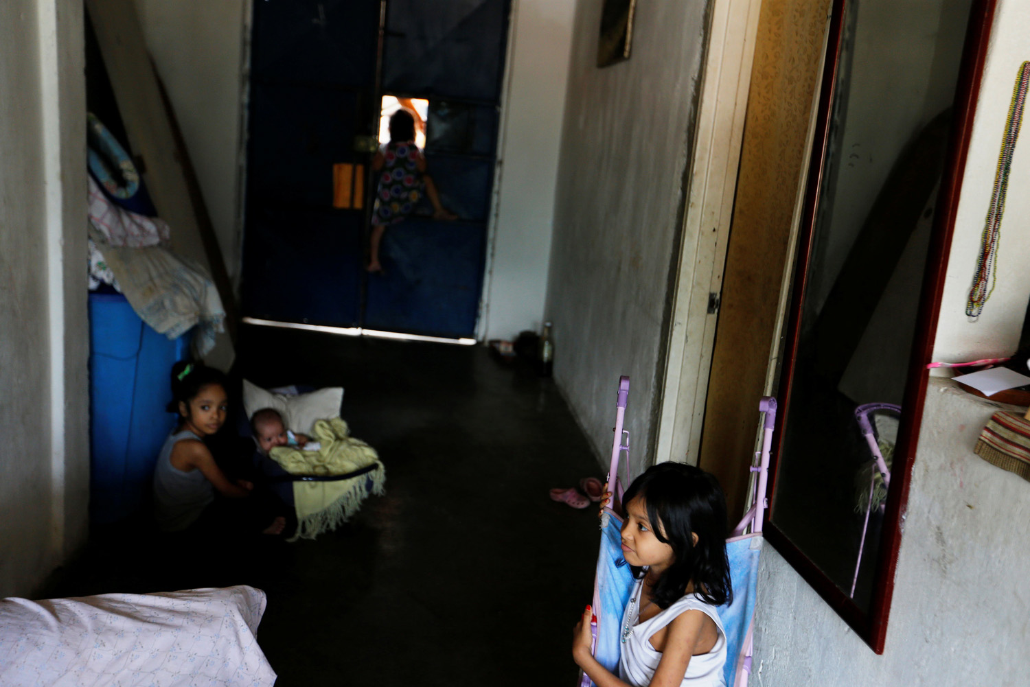 Los niños de Yennifer Padrón y Victor Cordova juegan en la sala de la casa que comparten en la favela de Petare en Caracas, Venezuela, 21 de agosto de 2017. Foto tomada el 21 de agosto de 2017. Para coincidir con la característica VENEZUELA-NIÑOS / REUTERS / Andres Martínez Casares
