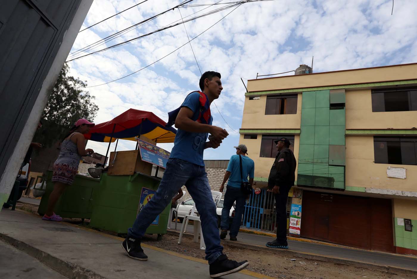 Los migrantes venezolanos caminan fuera de un refugio para los venezolanos en San Juan de Lurigancho, en las afueras de Lima, Perú 9 de marzo de 2018. REUTERS / Mariana Bazo