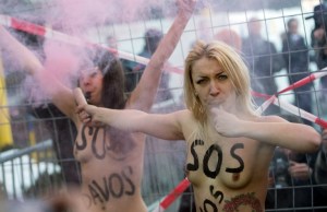 Tres activistas en “topless” protestan en Davos contra el foro (Fotos)
