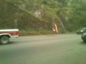Hombre con una bandera de Venezuela camina la autopista GMA (Fotos)