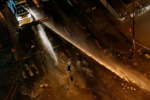 The national guard disperses water cannons on anti-government protesters during a protest at Altamira square in Caracas