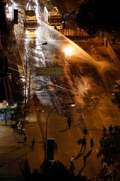 National guard disperses water cannons on anti-government protesters during a protest at Altamira square in Caracas