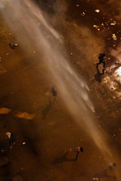 Anti-government protesters run away from a water cannon used by the national guard during a protest at Altamira square in Caracas