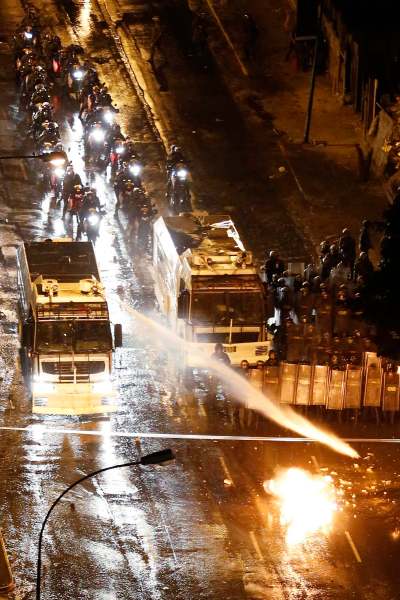 National guard disperses water cannons on anti-government protesters as a petrol bomb explodes near them during a protest at Altamira square in Caracas