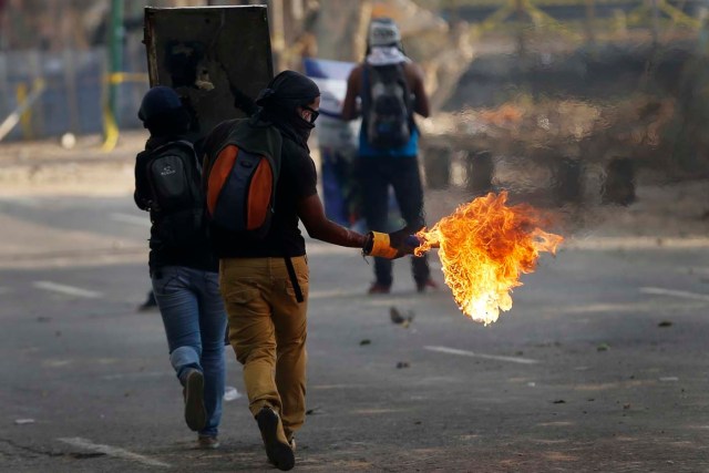 An anti-government protester holds a molotov cocktail during clashes with police at Altamira square in Caracas