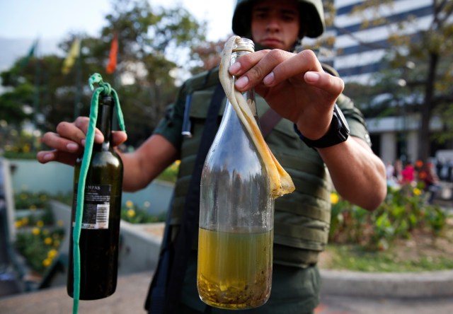 A National Guard shows bottles of molotov cocktails seized at Altamira square in Caracas