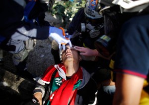 Anti-government protesters check a fellow protester after he was injured during a rally in Caracas