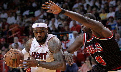 Miami Heat's James drives against Chicago Bulls' Deng in first half NBA game in Miami