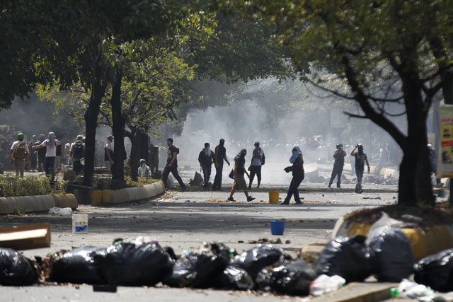 Anti-government protesters clash with the national police during riots in Caracas