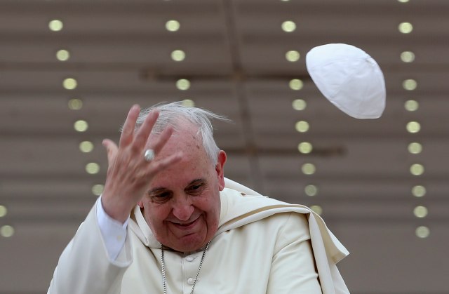 A gust of wind blows off Pope Francis' cap during his weekly general audience at St. Peter's Square at the Vatican