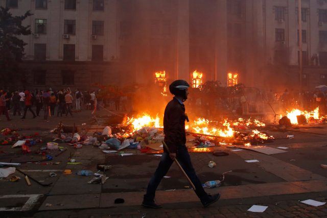 Un manifestante pasa junto a un campo de la tienda en llamas y un incendio en el edificio sindical en Odessa 02 de mayo 2014. Al menos 38 personas murieron en un incendio el viernes en el edificio de los sindicatos en el centro de la ciudad portuaria del sur de Ucrania de Odessa, dijo la policía regional. REUTERS / Yevgeny Volokin