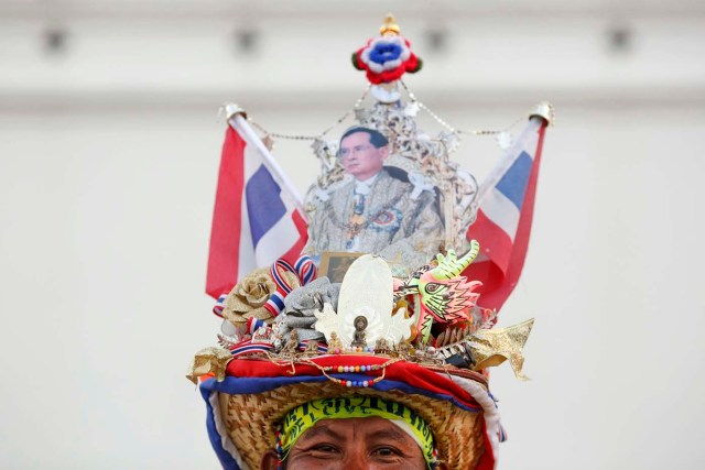 Este hombre lleva un sombrero con una imagen de rey de Tailandia Bhumibol Adulyadej cuando se une a los manifestantes antigubernamentales recolección fuera del gran palacio el día de la coronación en Bangkok