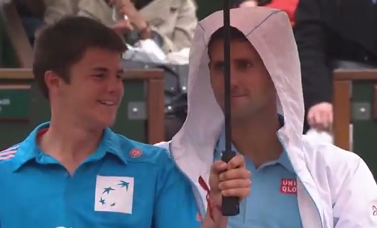 Y en plena lluvia, Djokovic invita un trago a recoge pelotas (Video)