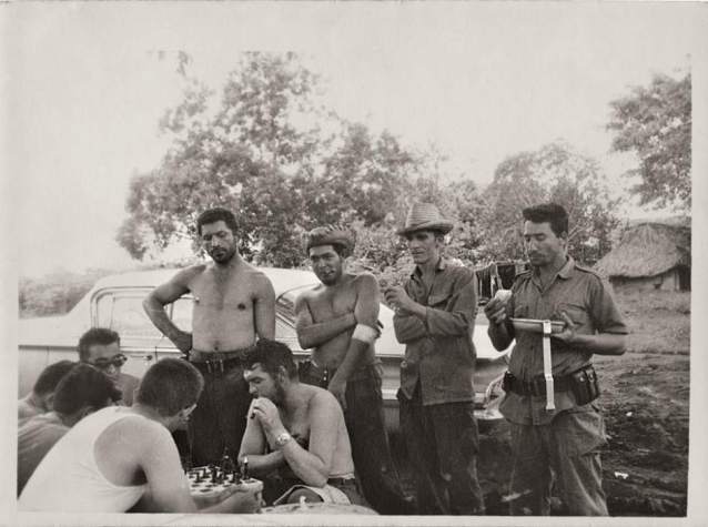 Ernesto 'Che' Guevara en Camagüey en 1964, jugando al ajedrez con sus escoltas y recolectores de caña de azúcar. Al fondo se ve el Chevrolet del año 1959 que utilizaba (Photo Courtesy: The Monacelli Press) 
