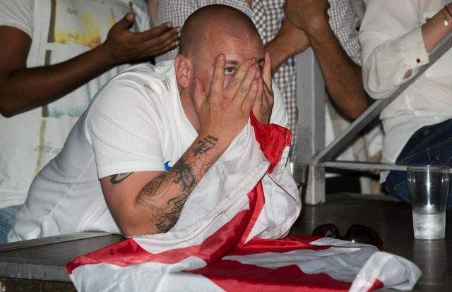 An England soccer fan reacts as he watches his team play against Italy during the 2014 World Cup at a bar in central London