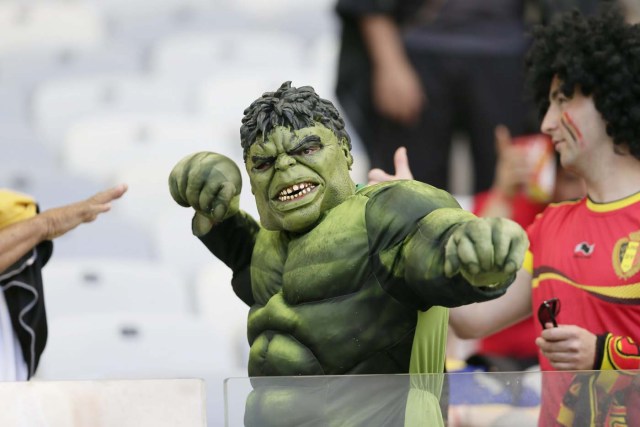Partidarios animan con un hombre vestido como jugador Bazilian y carácter cómico Hulk (C) antes de la Copa Mundial de la FIFA 2014 (Dennis Sabangan / EFE)