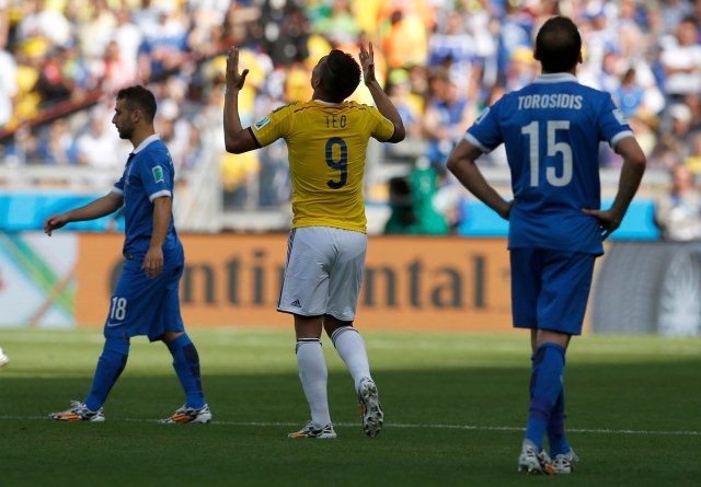 Greece's Fetfatzidis and Greece's Torosidis as Colombia's Gutierrez celebrates goal during 2014 World Cup soccer match in Belo Horizonte