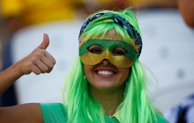 A fan gestures before the opening ceremony of the 2014 World Cup at the Corinthians arena in Sao Paulo