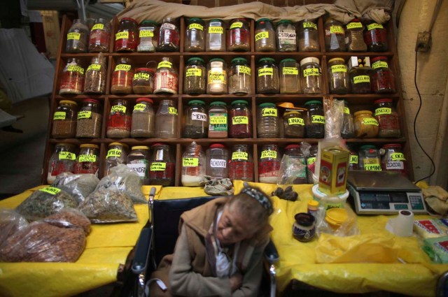 Una mujer dormita junto a ella la especia de pie en el mercado de alimentos de San Juan en la ciudad de México ( Edgard Garrido / Reuters)