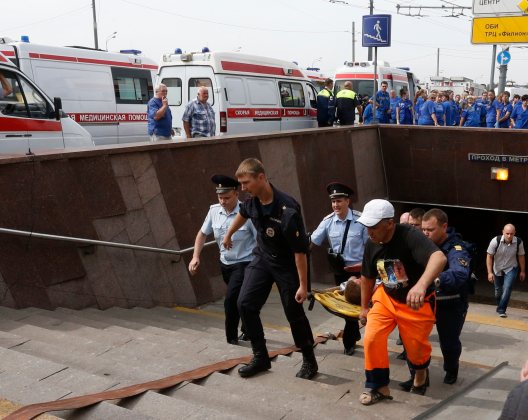Members of the emergency services carry an injured passenger outside a metro station following an accident on the subway in Moscow