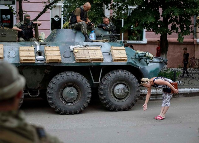 Una mujer de la localidad saluda soldados ucranianos en el centro de Slaviansk ( Gleb Garanich / Reuters)