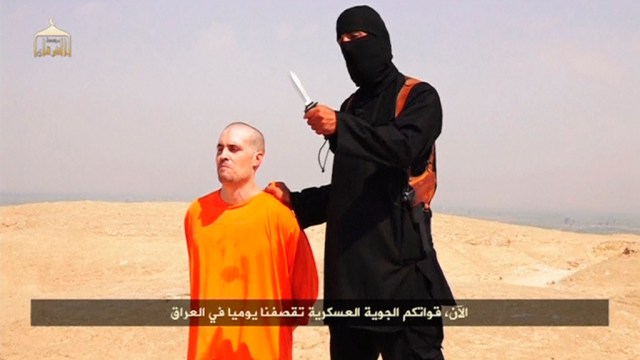 Still image from undated video of a masked Islamic State militant holding a knife speaking next to man purported to be James Foley at an unknown location