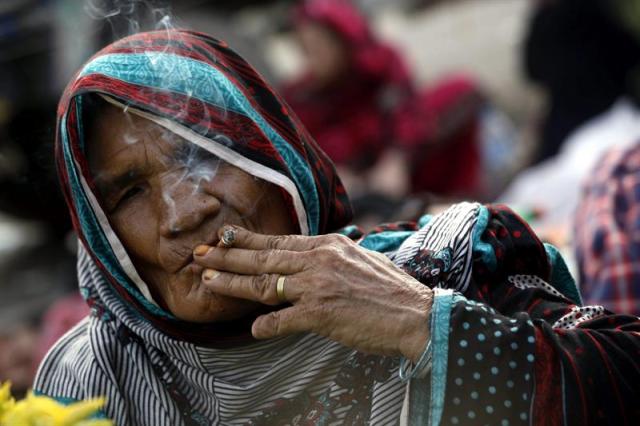 Un simpatizante del clérigo Tahirul Qadri fuma un cigarro durante una protesta en Islamabad (Pakistán) (foto EFE / Bilawal Arbab)