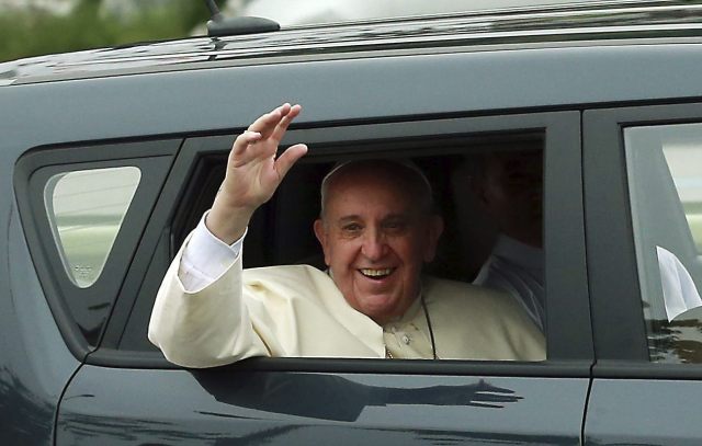 El papa Francisco saluda a los ciudadanos mientras se dirige al centro de la ciudad a bordo de un pequeño utilitario tras aterrizar en Seúl (EFE)
