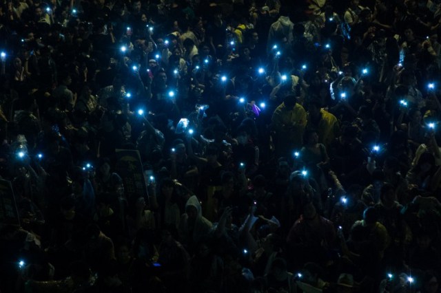 Manifestantes pro democracia en Hong Kong iluminan con sus teléfonos celulares luego de una fuerte lluvia (Foto Philippe Lopez / AFP)