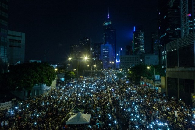 Manifestantes pro democracia en Hong Kong iluminan con sus teléfonos celulares luego de una fuerte lluvia (Foto Philippe Lopez / AFP)