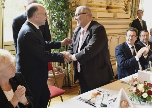 El ministro del Interior francés, Bernard Cazeneuve (L) estrecha la mano del rector de la mezquita de Lyon Kamel Kabtane (C) después de su discurso durante una ceremonia para conmemorar el 20 aniversario de la mezquita del Lyon (Foto Philippe Desmazes / AFP)