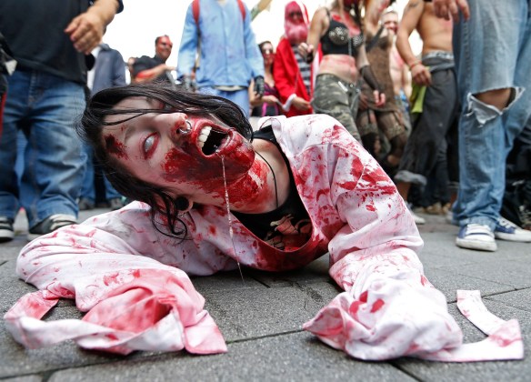 A participant crawls on the ground during a "Zombie Walk" in Strasbourg