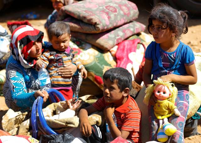 Refugiados kurdos sirios llevan sus pertenencias después de cruzar la frontera sirio-turca, cerca de la ciudad del sudeste de la provincia de Sanliurfa Suruc (Foto Murad Sezer / Reuters)